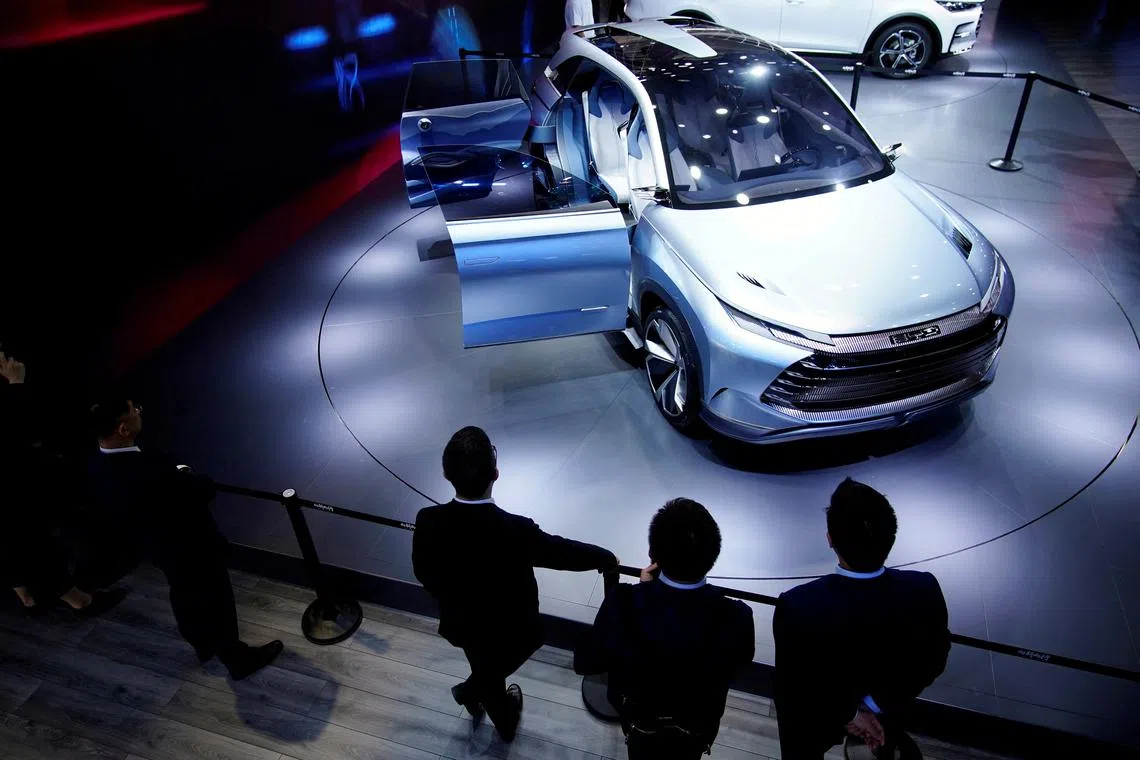 People stand near a BYD X Dream electric vehicle (EV) displayed during a media day for the Auto Shanghai show in Shanghai, China on April 19, 2021. 