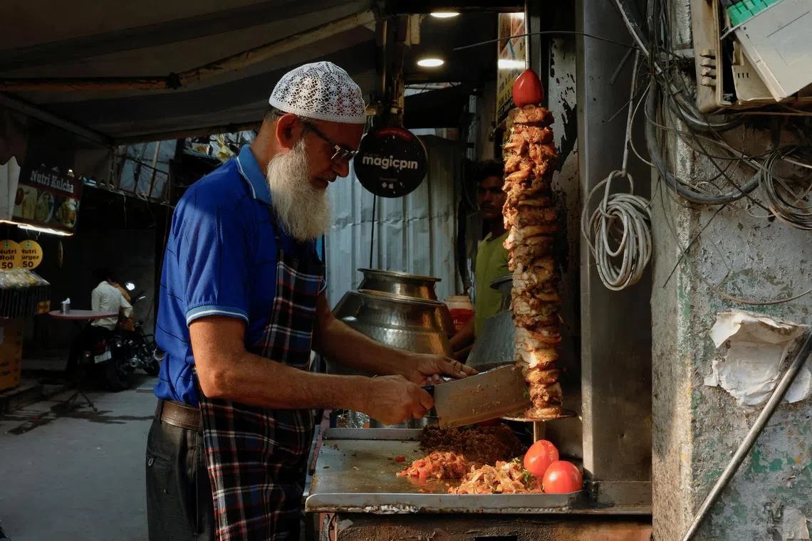 A chef slices shawarma at a roadside food stall in New Delhi.
