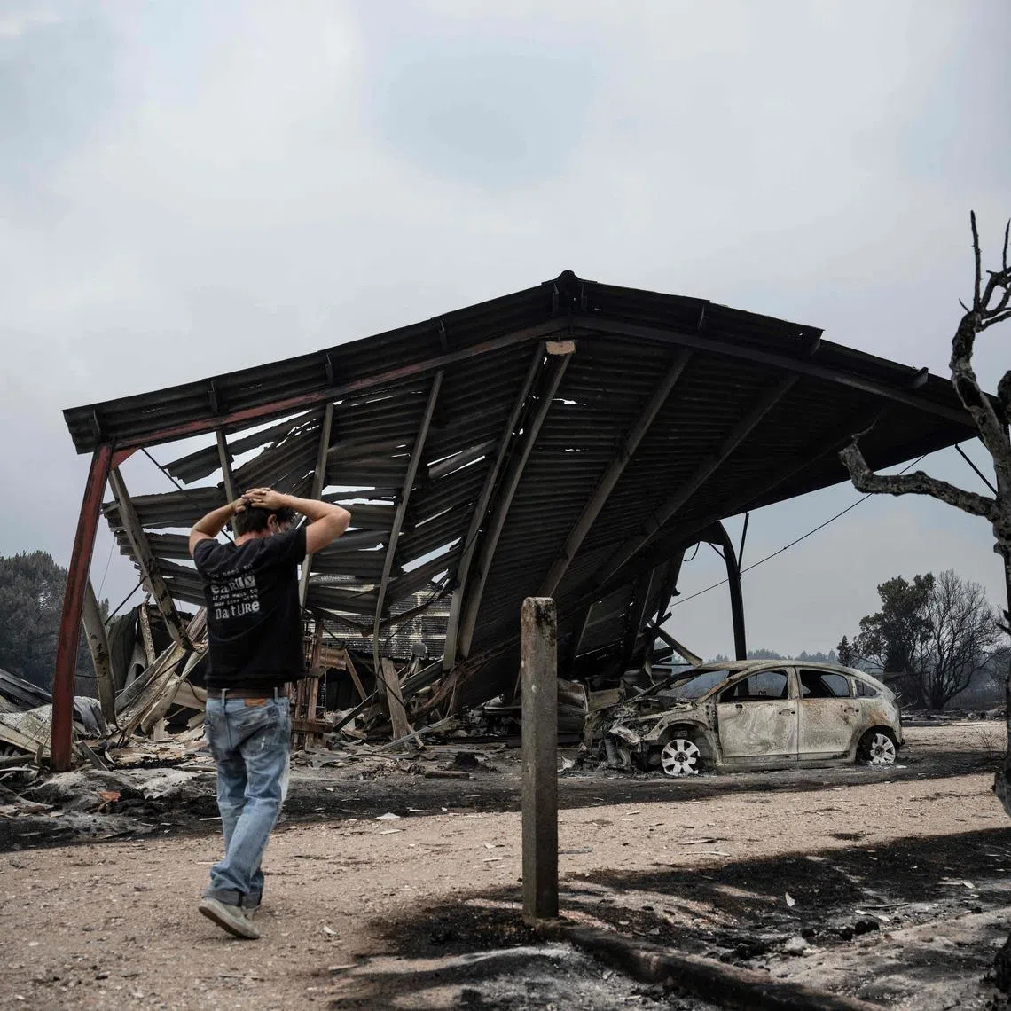A resident inspects the damage after a wildfire in south-western France on July 25.