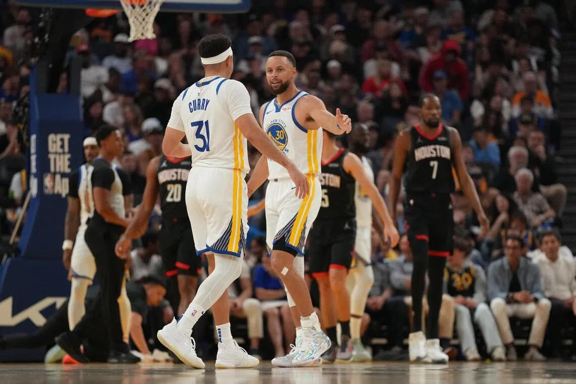 Golden State Warriors guards and brothers  Stephen Curry (right) and Seth Curry after a play against the Houston Rockets in the second quarter on April 6.