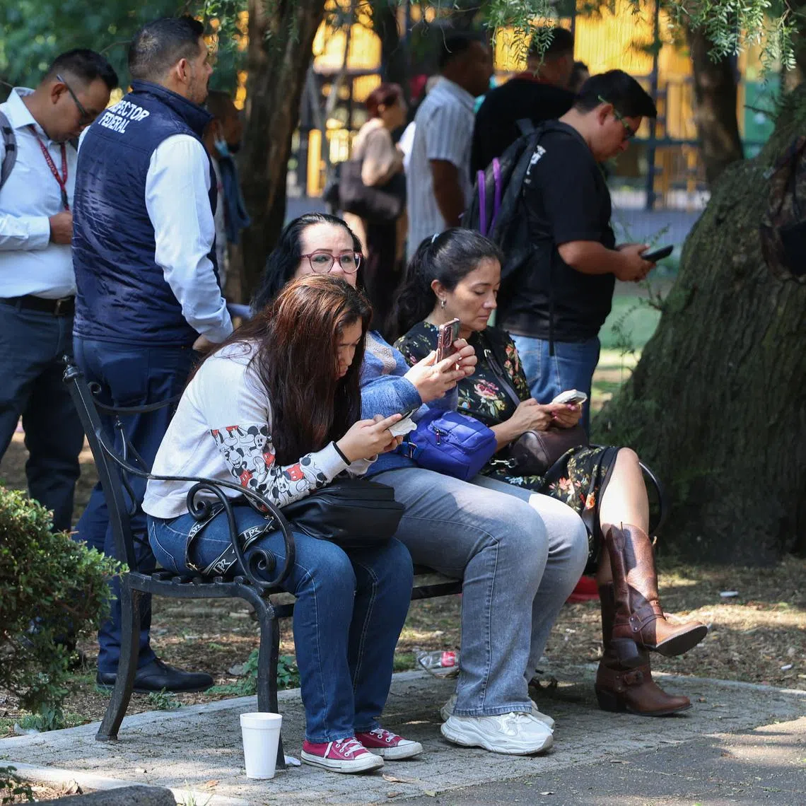 People sit on a bench while they wait outside, after an earthquake alarm sounded warning of a tremor, in Mexico City, Mexico, May 4, 2026. REUTERS/Luis Cortes