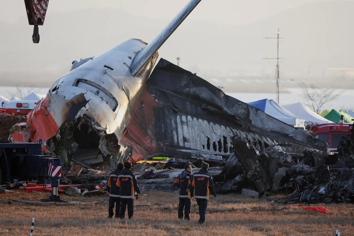 FILE PHOTO: Firefighters take a look at the wreckage of the aircraft that crashed after it went off the runway, at Muan International Airport, in Muan, South Korea, December 31, 2024. REUTERS/Kim Hong-Ji/File Photo