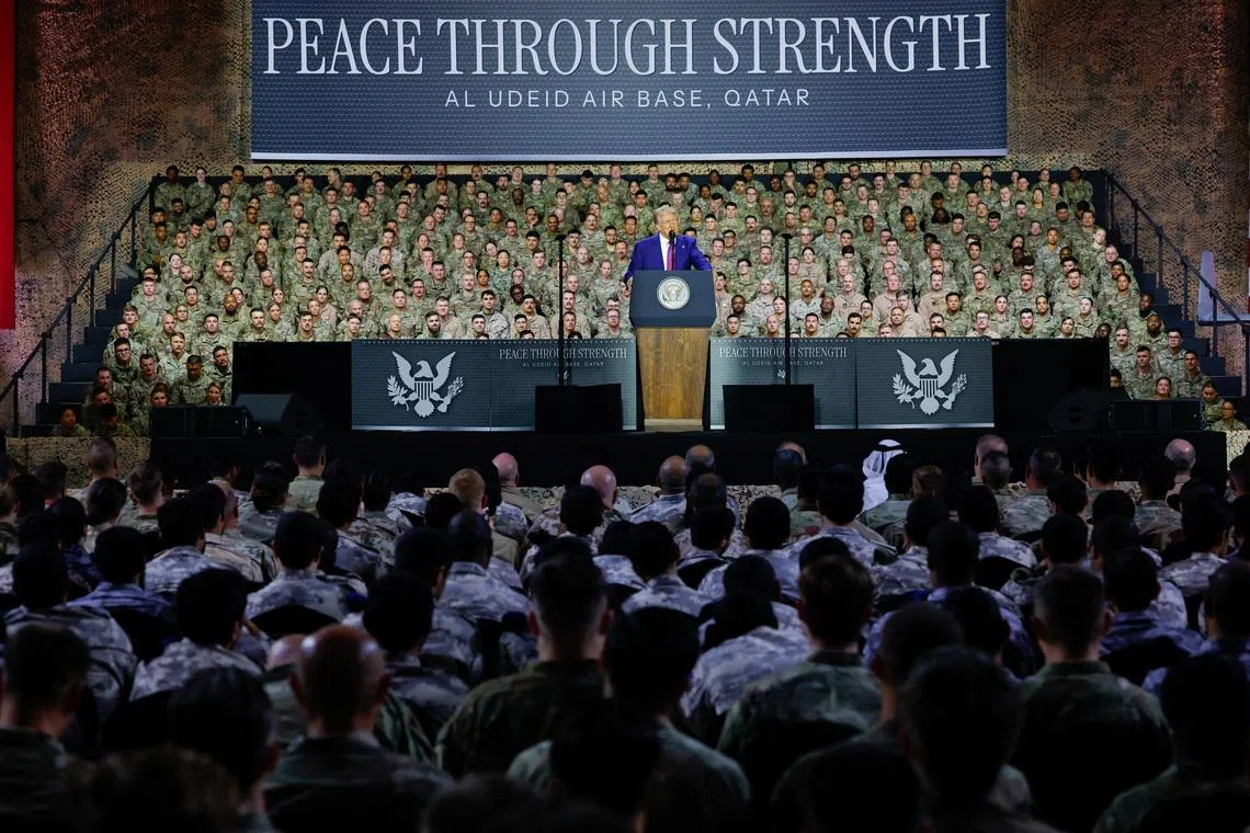 U.S. President Donald Trump delivers remarks to U.S. troops, in front of a banner reading, \"Peace Through Strength\", during a visit to Al Udeid Air Base in Doha, Qatar, May 15, 2025. REUTERS/Brian Snyder