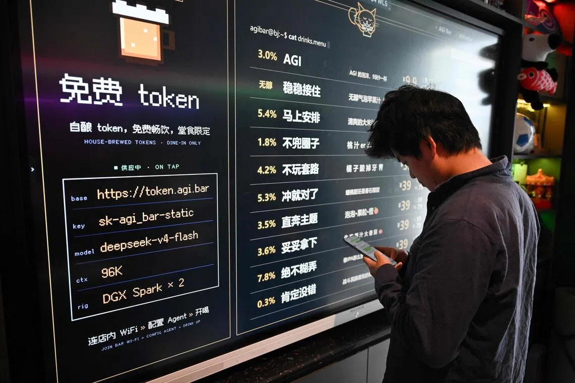 A customer uses his phone in front of a board with the menu at the AI-themed AGI Bar in Beijing’s Zhongguancun district.