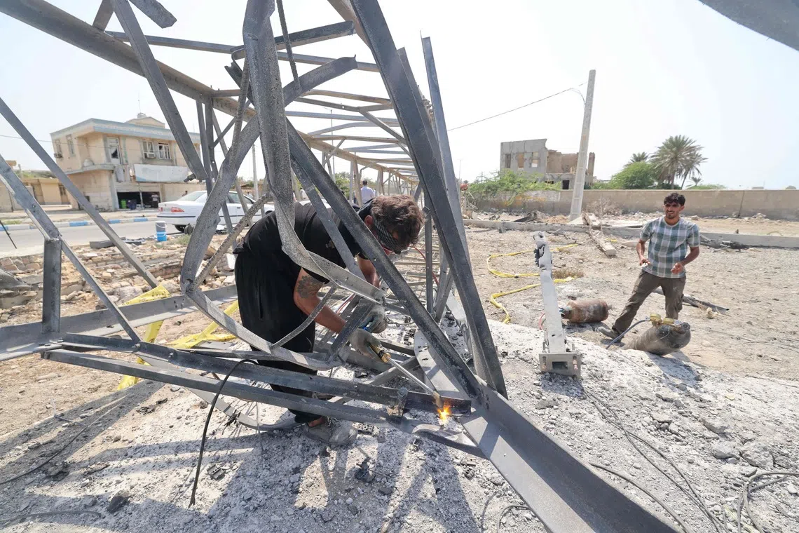 Workers solder the remains of a telecommunications tower destroyed following a US military strike earlier in the week on Kuhestak, Sirik County, in Iran's southern Hormozgan province on September 6, 2026. A deadly US strike hit a wedding celebration on the night of September 2, 2026, in the coastal town of Kuhestak along Strait of Hormuz in southern Iran, with the Iranian authorities saying it killed at least four people, including a child, and wounded 68 others attending the wedding. The United States announced attacks against targets belonging to Iran's Revolutionary Guards. Iran has been at war since February 28, when the United States and Israel launched a surprise bombing campaign that killed its supreme leader. (Photo by ATTA KENARE / AFP) /
