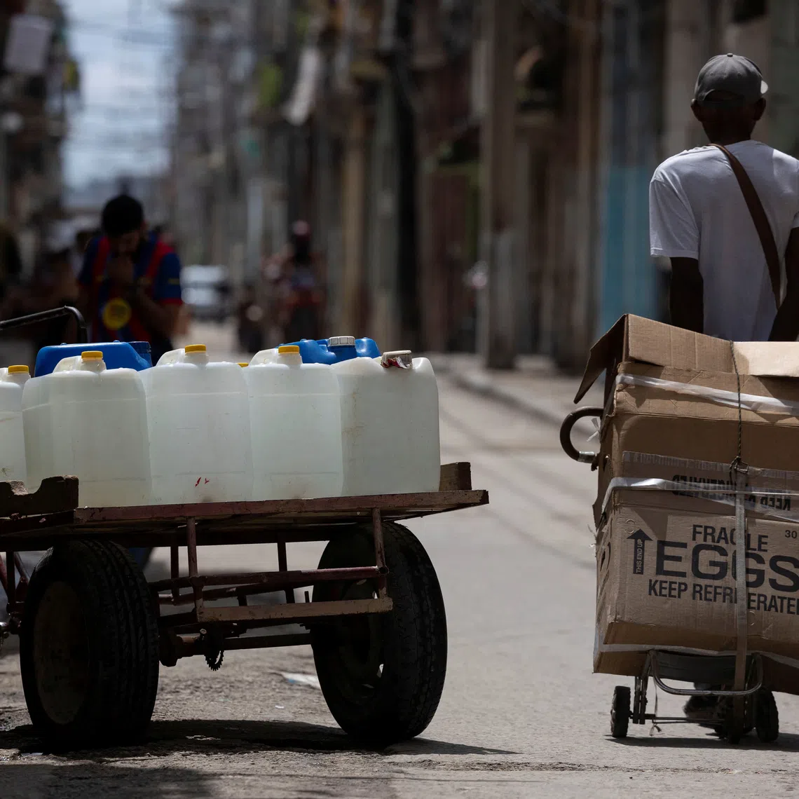Water containers on a cart beside a man transporting boxes of eggs along a street, as water and electricity shortages complicate hygiene amid a wave of viral illnesses in Havana, Cuba, September 24, 2026. REUTERS/Ricardo Arduengo
