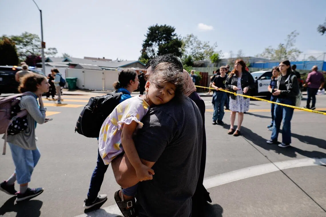 A parent carries his child while they leave the mosque, at the scene of a shooting at the Islamic Center in San Diego, California, on May 18.