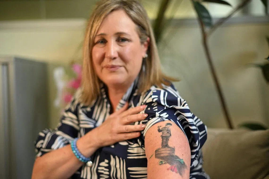 Ms Mia Bannister shows a tattoo dedicated to her son, Ollie, who took his own life after being bullied online.