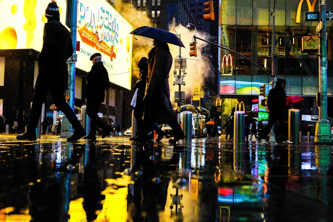 Pedestrians walking on Dec 2 under umbrellas in the rain in Midtown Manhattan, New York City.