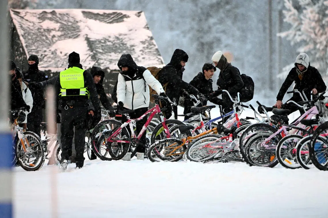 FILE PHOTO: Migrants arrive with bicycles to the international border crossing at Salla, northern Finland, November 23, 2023.  Lehtikuva/Jussi Nukari via REUTERS/File Photo