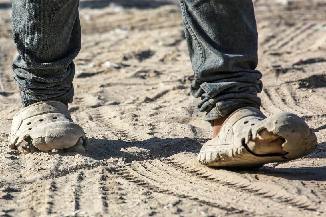 A Palestinian walks in damaged shoes in Khan Yunis.