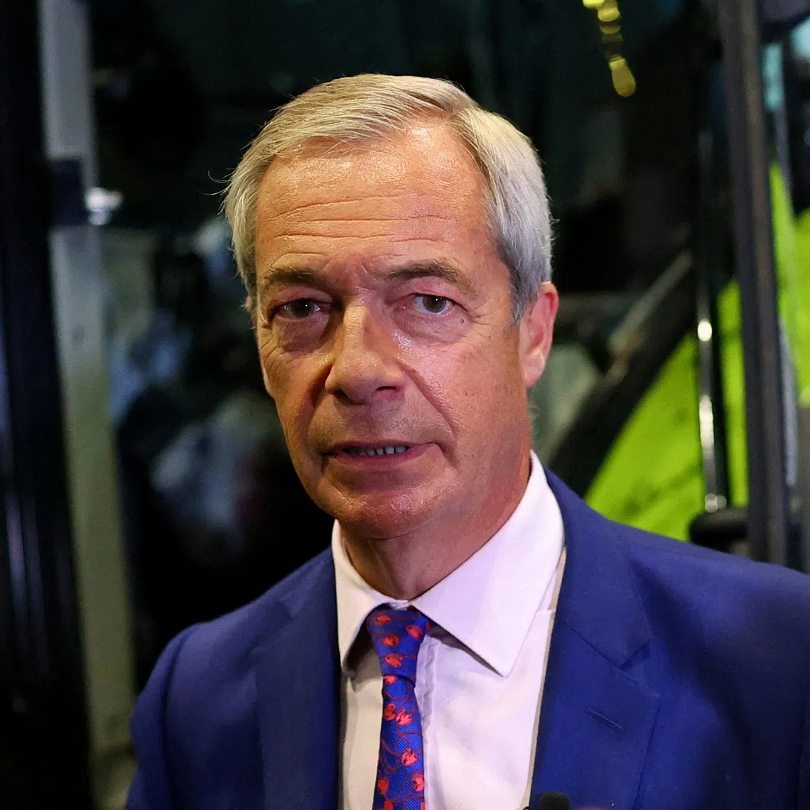 FILE PHOTO: Britain's Reform UK party leader Nigel Farage stands next to a tractor during the Reform UK party conference, in Birmingham, Britain, September 6, 2025. REUTERS/Isabel Infantes/File Photo