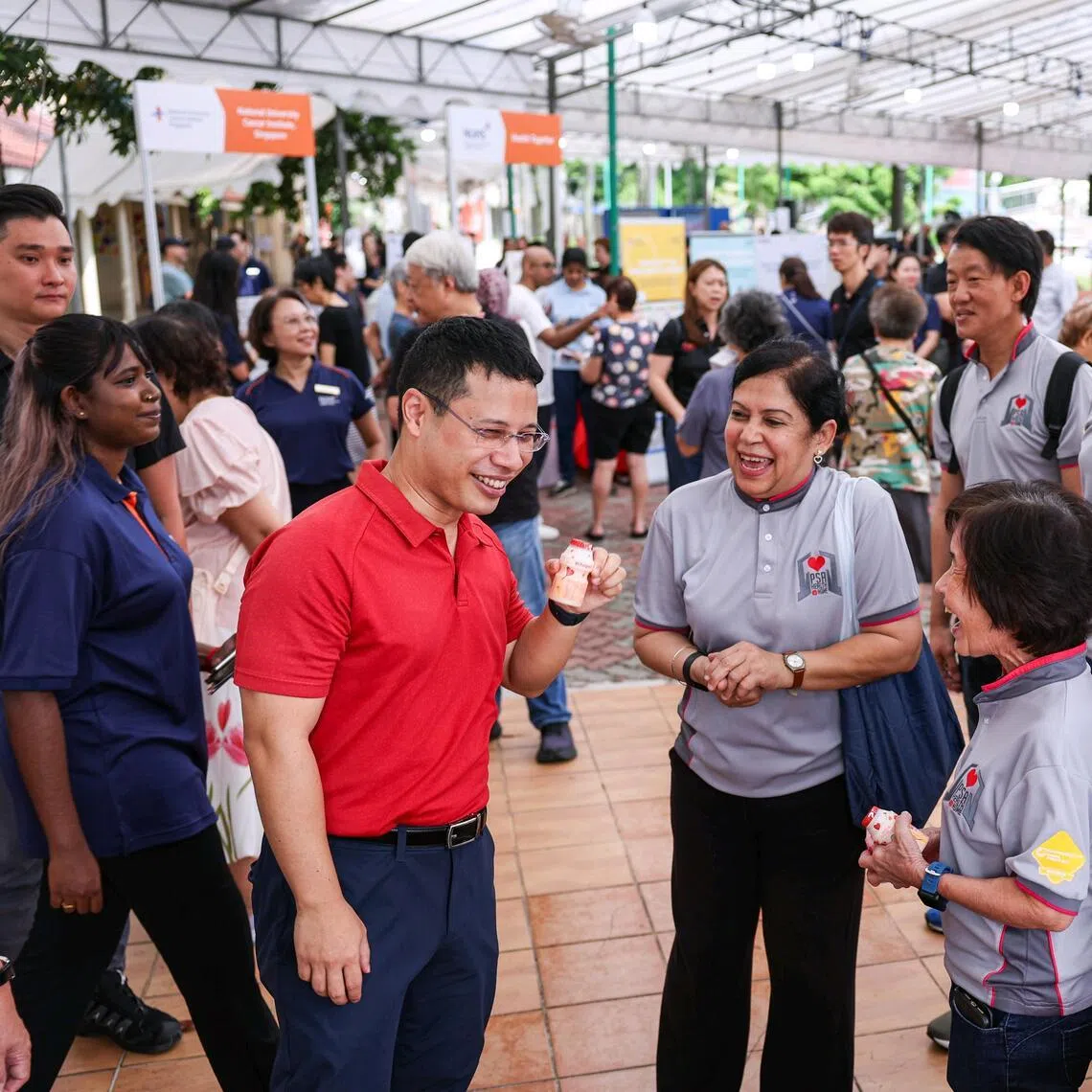 *EMBARGO UNTIL 1PM* Minister for Education Desmond Lee interacting with volunteers from PSA?s Health@Home initiative while holding a Yakult drink at the Health Together Carnival in West Coast on March 28, 2026. ST PHOTO: BRIAN TEO