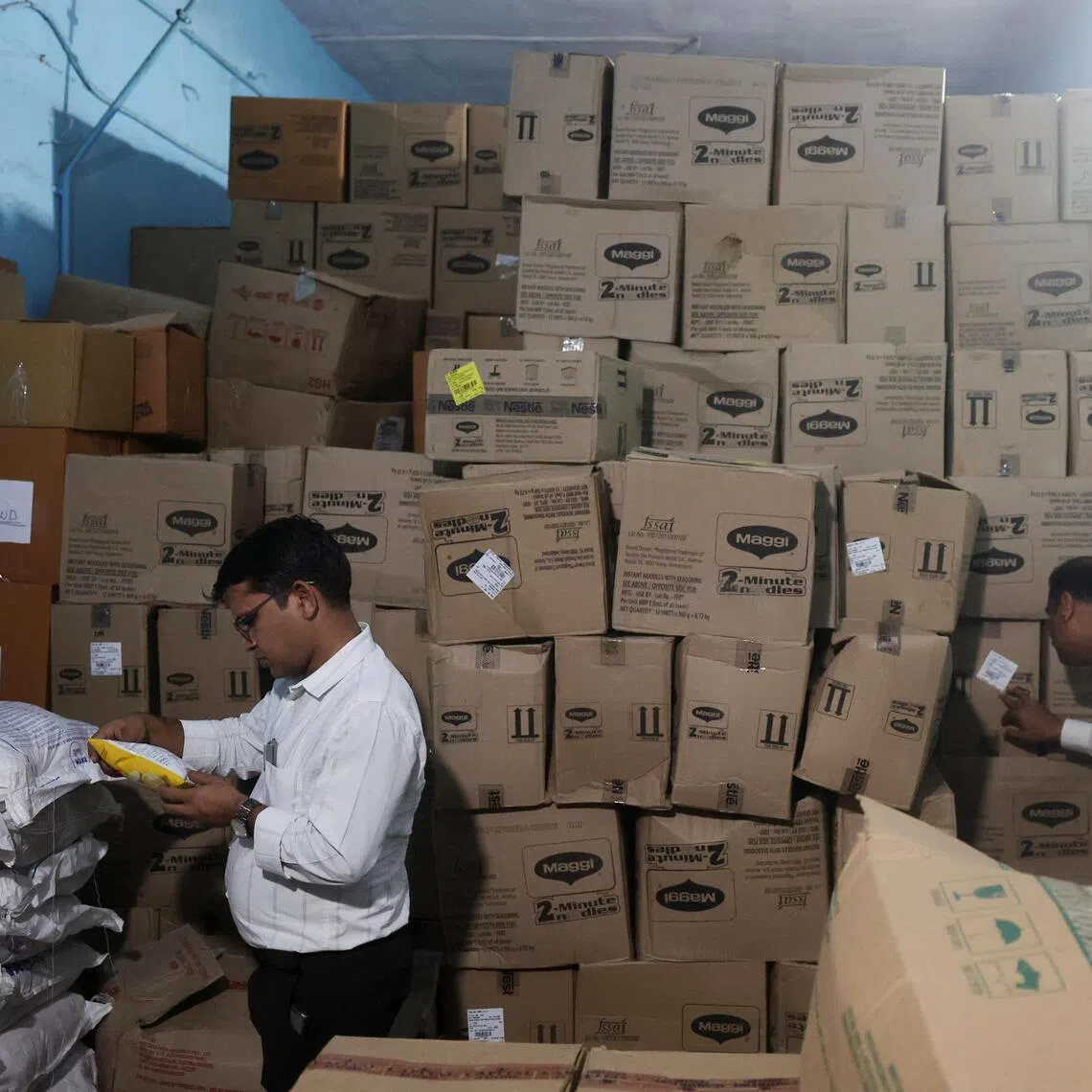 Maharashtra Food and Drug Administration (FDA) officials inspect duplicate labels bearing altered ingredient information during a raid at a warehouse in India on Aug 25.