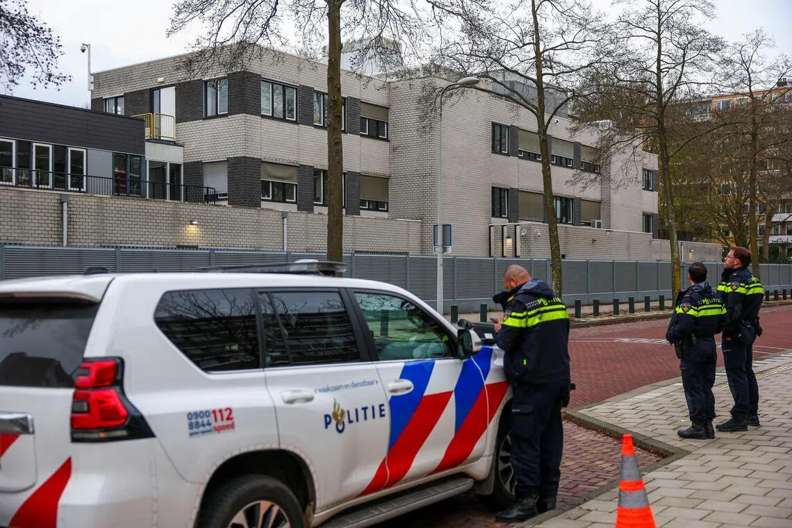 Police officers stand outside a Jewish school following an explosion that caused minor damages, in Amsterdam, Netherlands, on March 14, 2026.
