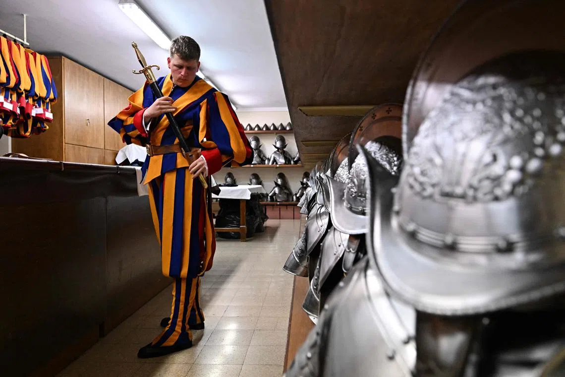 A new Swiss Guard preparing for daily training in the Vatican armoury at the Pontifical Swiss Guard headquarters, in the days leading up to the swearing-in ceremony of new Swiss Guard recruits at the Vatican. It takes over an hour to don the colourful uniform of the pope's Swiss Guards, and new recruits soon discover they cannot buckle up armour weighing 15 kilograms by themselves.