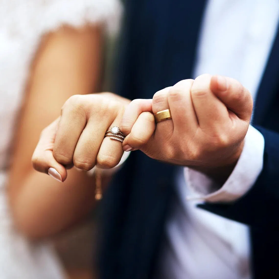 Cropped shot of an unrecognizable newlywed couple doing a pinky swear gesture on their wedding day