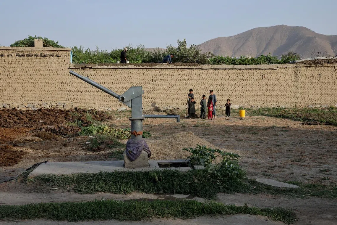 Children stand nearby a dried-up hand-pump, amid serious water crisis in Kabul, Afghanistan, August 29, 2025. REUTERS/Sayed Hassib