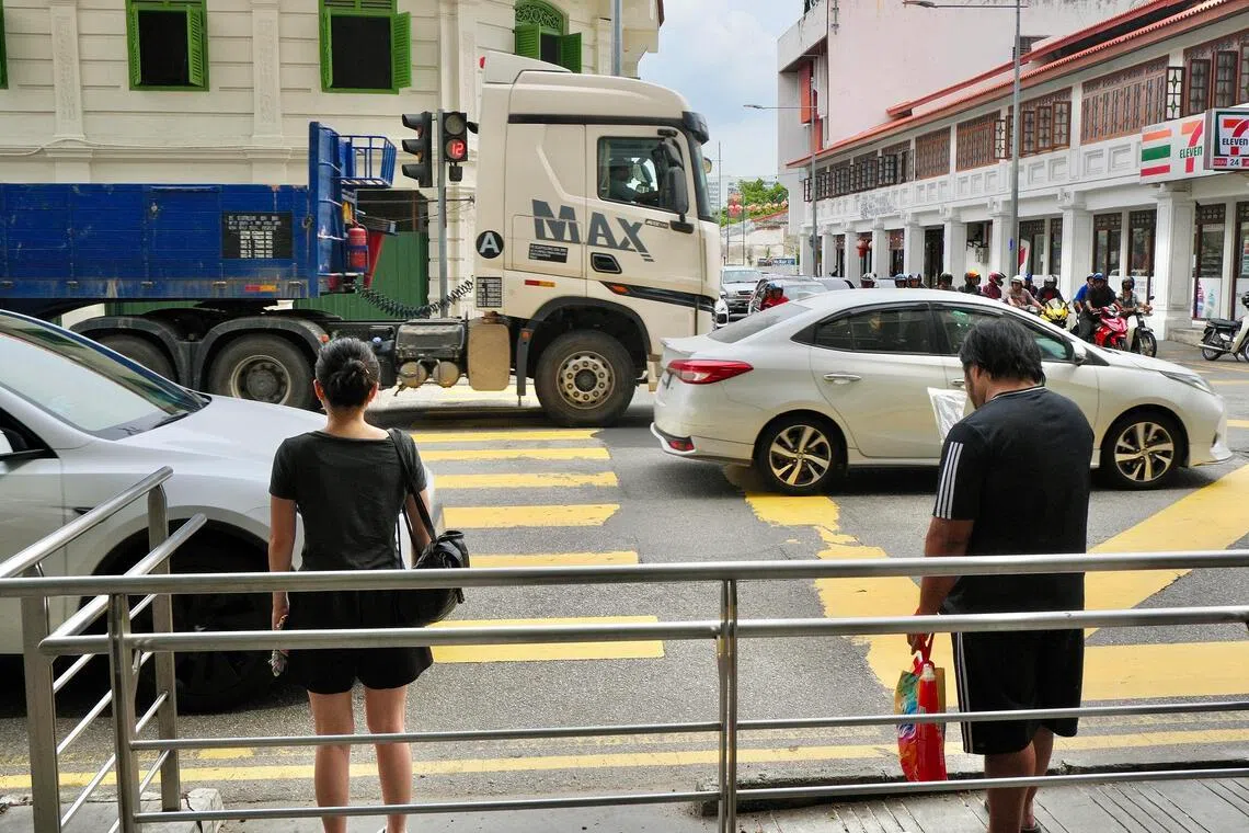 Pedestrians waiting to cross the busy Magazine Road in George Town.