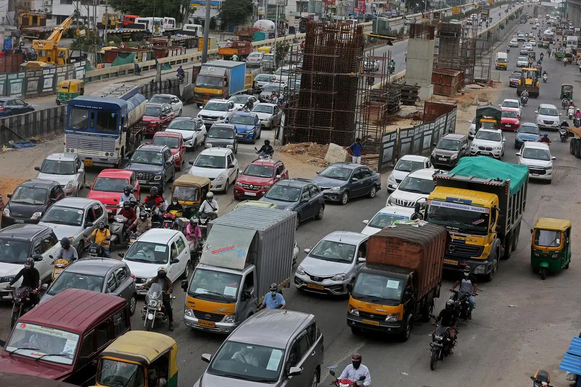Cars, trucks, rickshaws and motorists in a traffic jam in Bangalore, India.