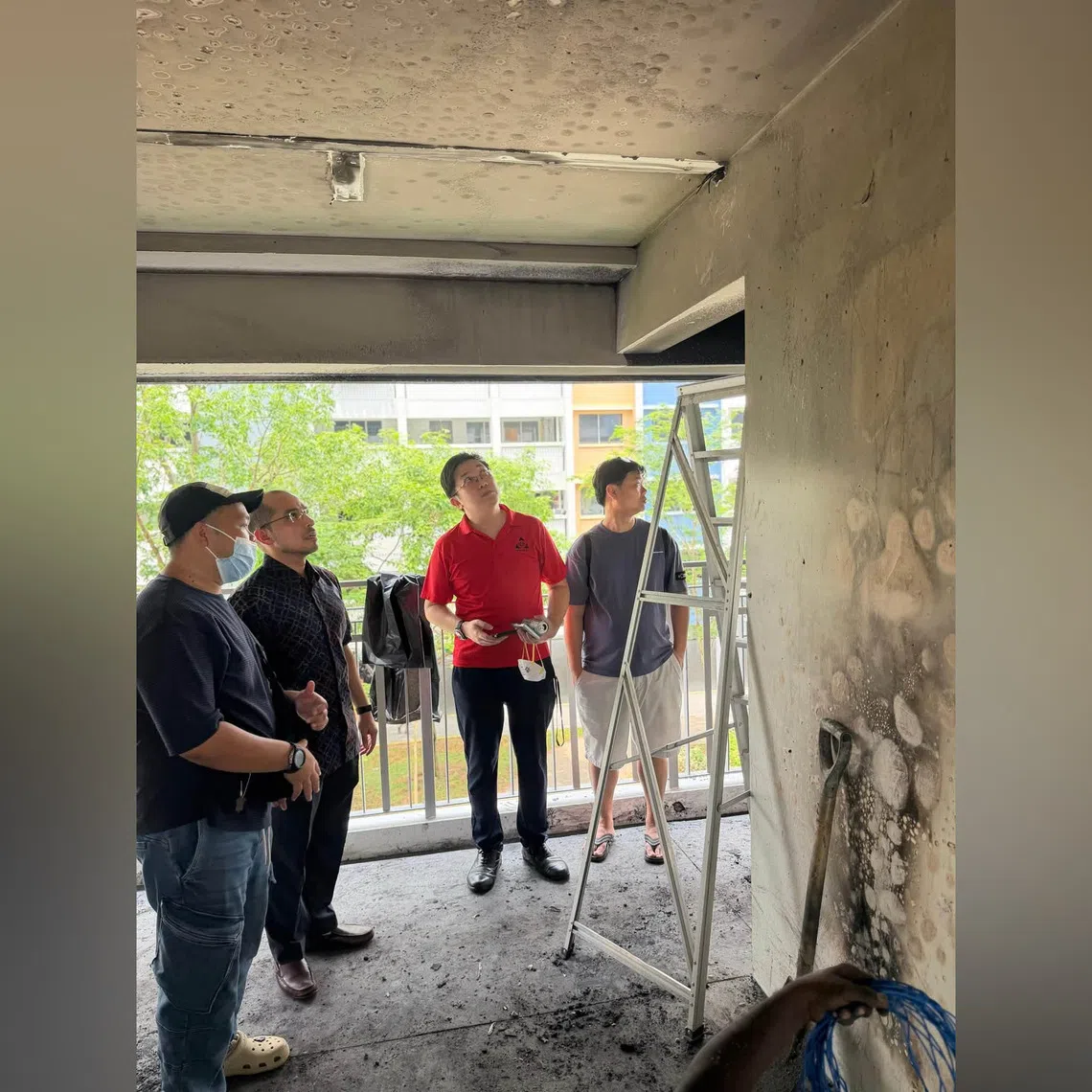 Nee Soon GRC MP Syed Harun Alhabsyi (2nd from left) and grassroots leaders looking at the damage caused by the PMA fire on the third-floor landing of Block 438 Yishun Ave 11.