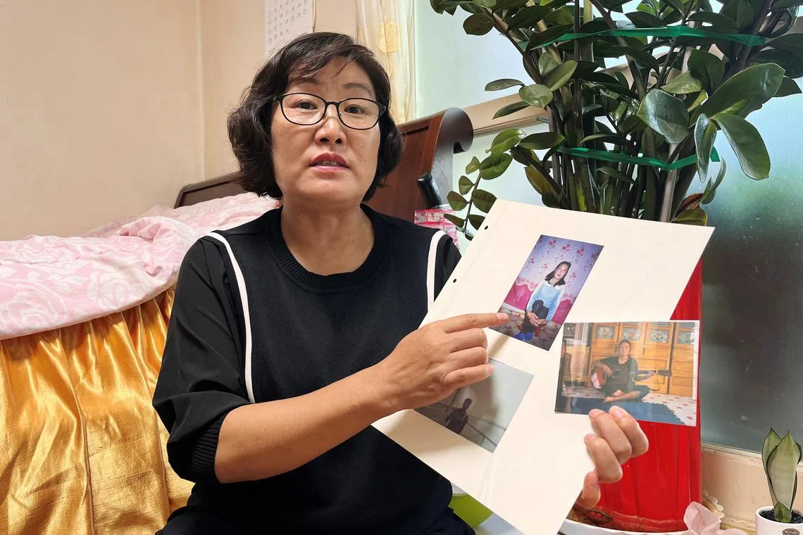 Choi Min-kyong, a North Korean defector who said she was deported by China four times before making it to South Korea in 2012, shows her old photos as she attends an interview with Reuters in Seoul, South Korea, July 19, 2024. REUTERS/Ju-min Park