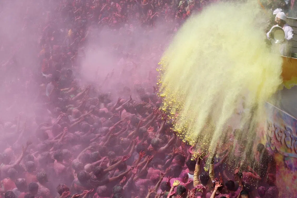 Hindu devotees are daubed in colored powder in a temple’s premises during Holi celebrations in Ahmedabad, India, on March 4, 2026. 