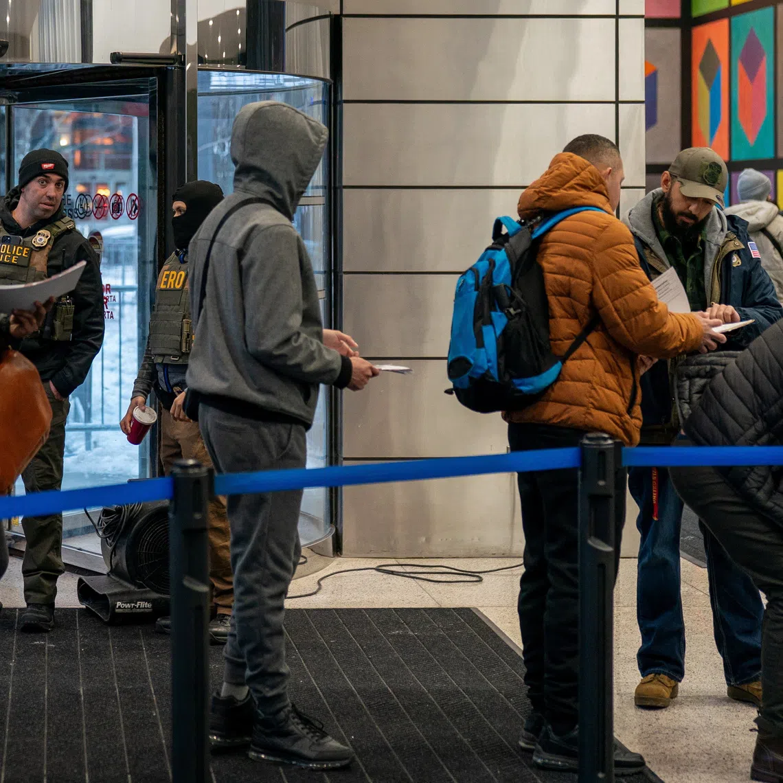 Immigration Customs Enforcement (I.C.E.) agents check the paperwork of respondents arriving at U.S. immigration court in Manhattan, New York City, U.S., December 15, 2025. REUTERS/David 'Dee' Delgado