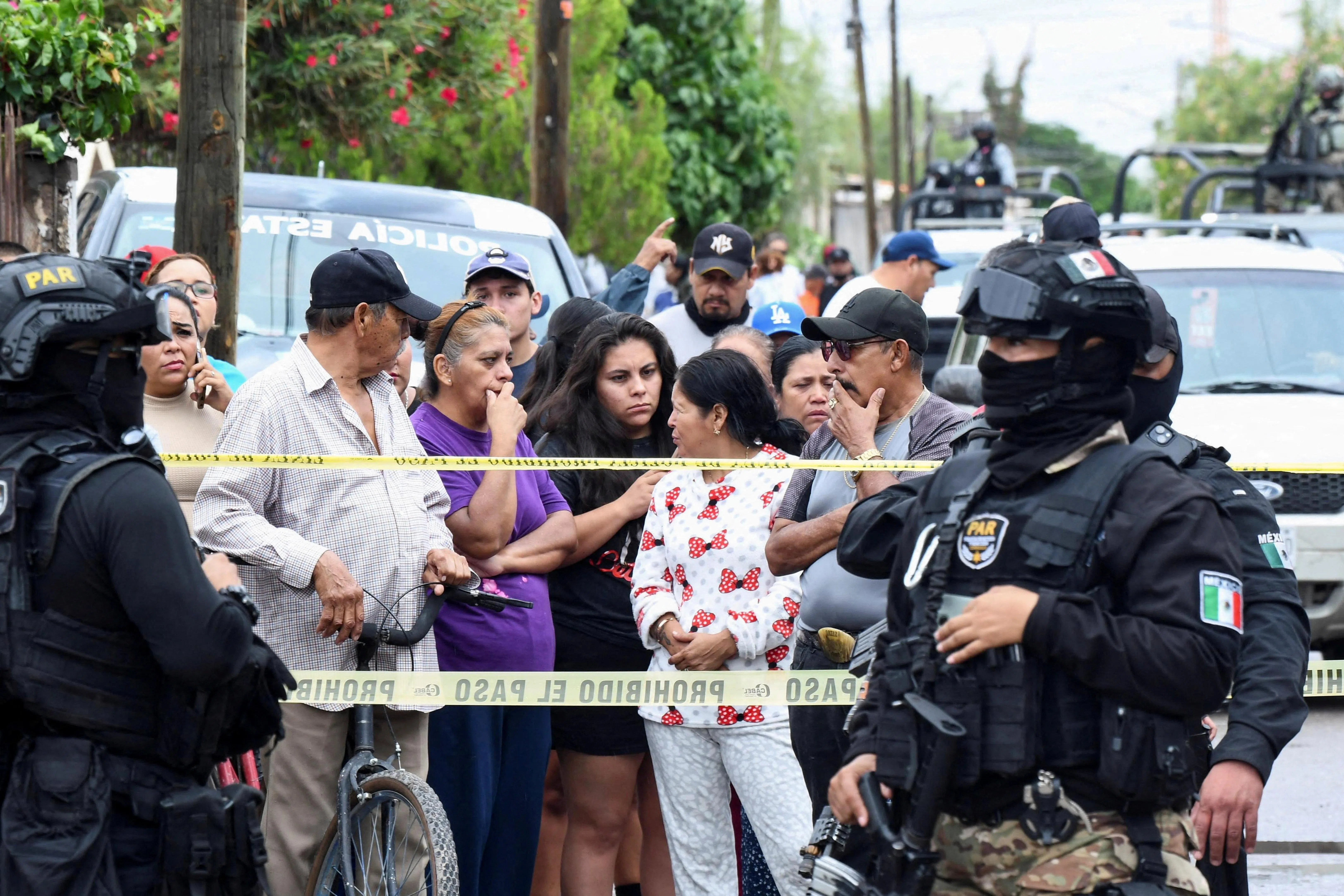 Onlookers stand behind a police cordon as security officers stand guard at Secondary School No. 13 after an attack that killed a vice principal and injured others, according to local authorities, in Torreon, Coahuila state, Mexico, October 1, 2026. REUTERS/Stringer     TPX IMAGES OF THE DAY