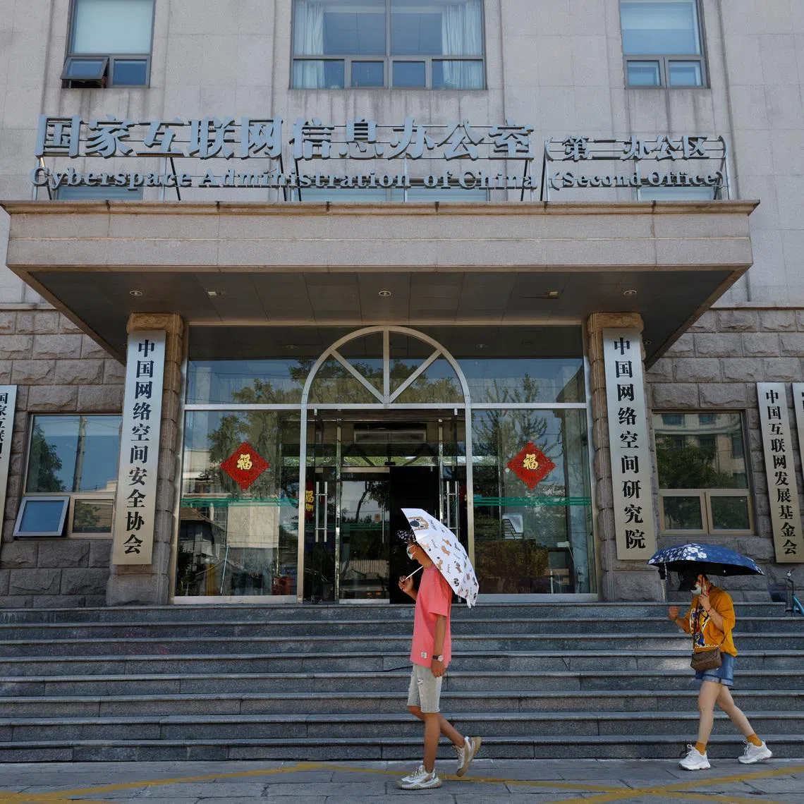 People walk past an office of the Cyberspace Administration of China (CAC) in Beijing, China July 8, 2021. REUTERS/Thomas Peter