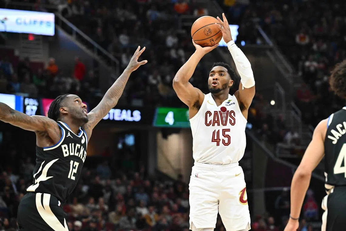 Donovan Mitchell of the Cleveland Cavaliers shoots over Taurean Prince of the Milwaukee Bucks during the third quarter at Rocket Mortgage Fieldhouse.