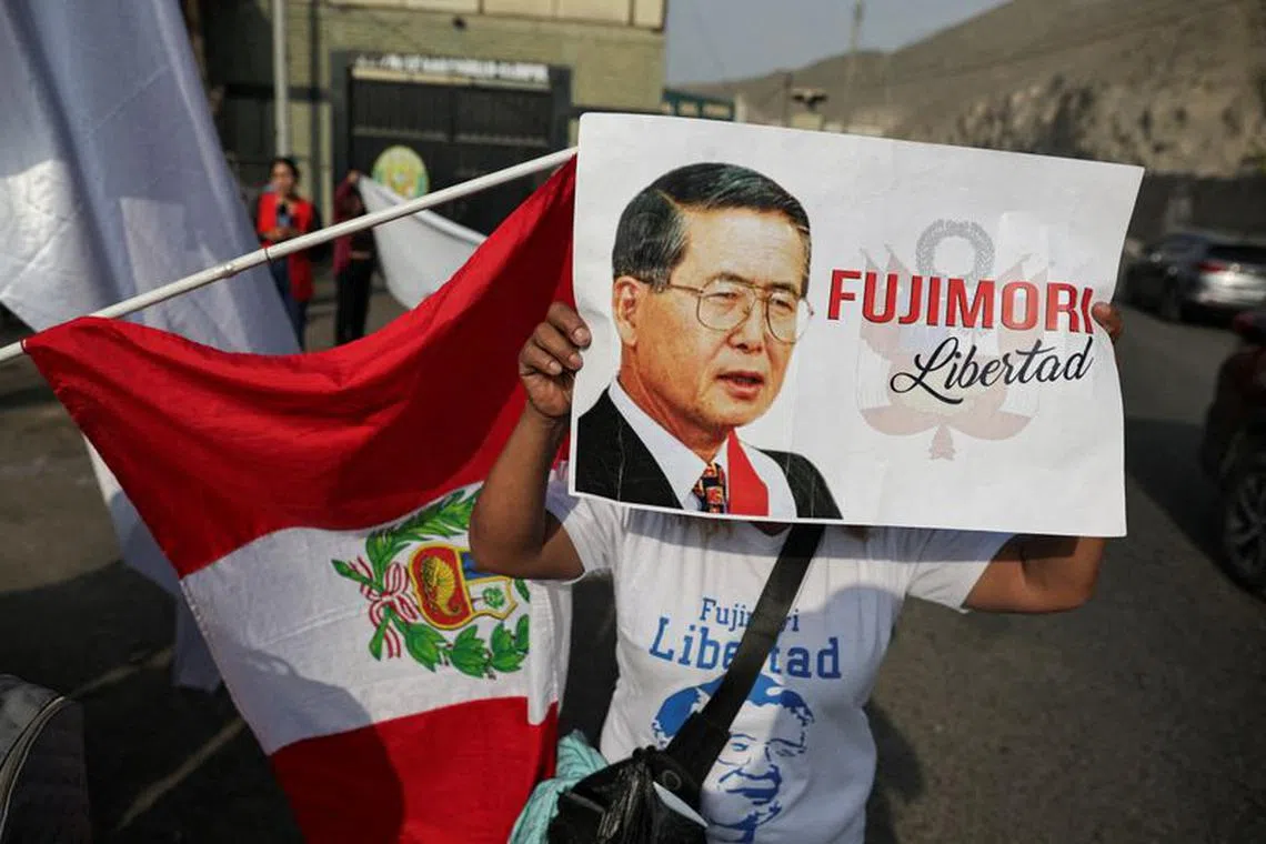 FILE PHOTO: A follower of Peruvian President Alberto Fujimori holding a placard stands outside a prison, after a top court reinstated the pardon of Fujimori, in Lima, Peru, November 29, 2023. REUTERS/Sebastian Castaneda/File Photo