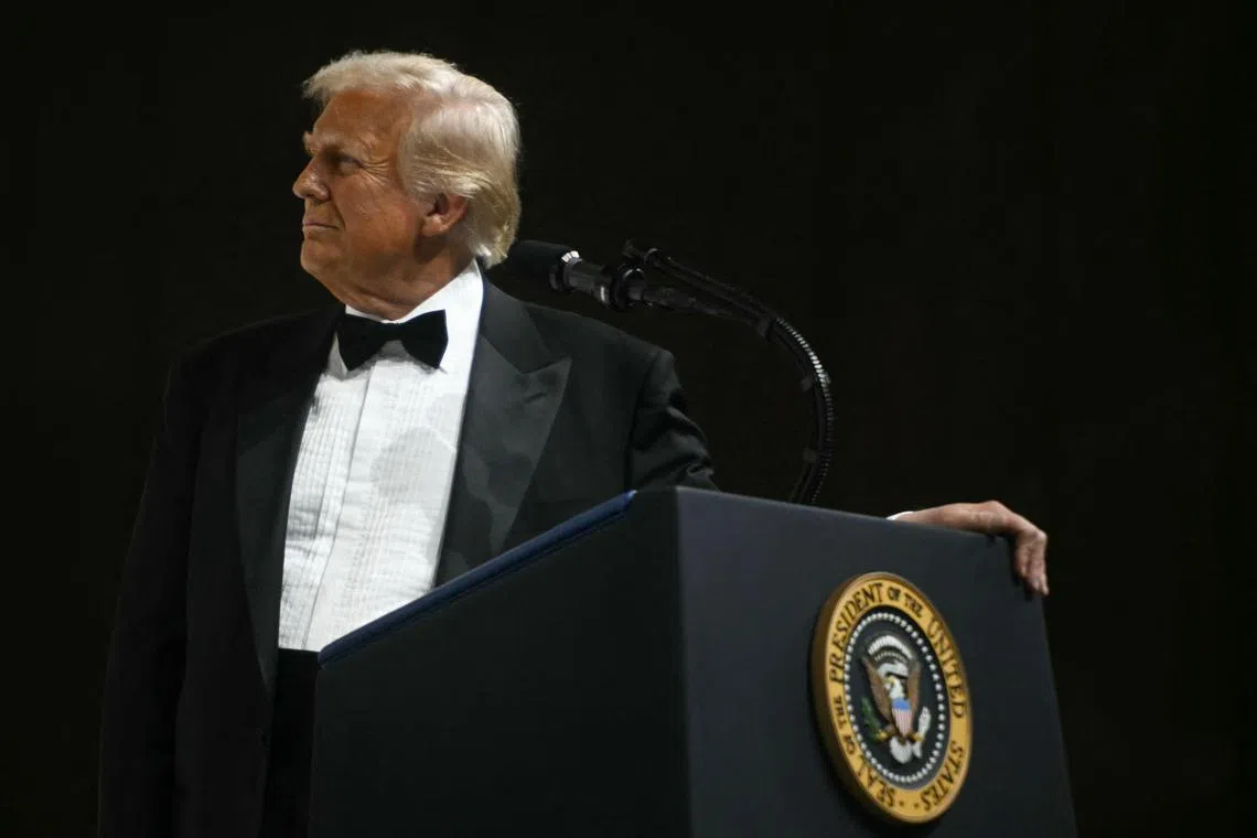 US President Donald Trump watches a screen as he speaks via video call with US troops stationned oversea during the Commander-In-Chief inaugural ball at the Walter E. Washington Convention Center in Washington, DC, on January 20, 2025. (Photo by Jim WATSON / AFP)