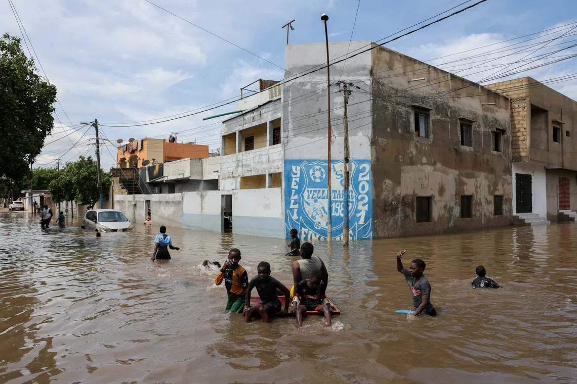 Children play in a flooded street following heavy rainfall in Dakar, Senegal, October 5, 2026. REUTERS/Misper Apawu TPX IMAGES OF THE DAY