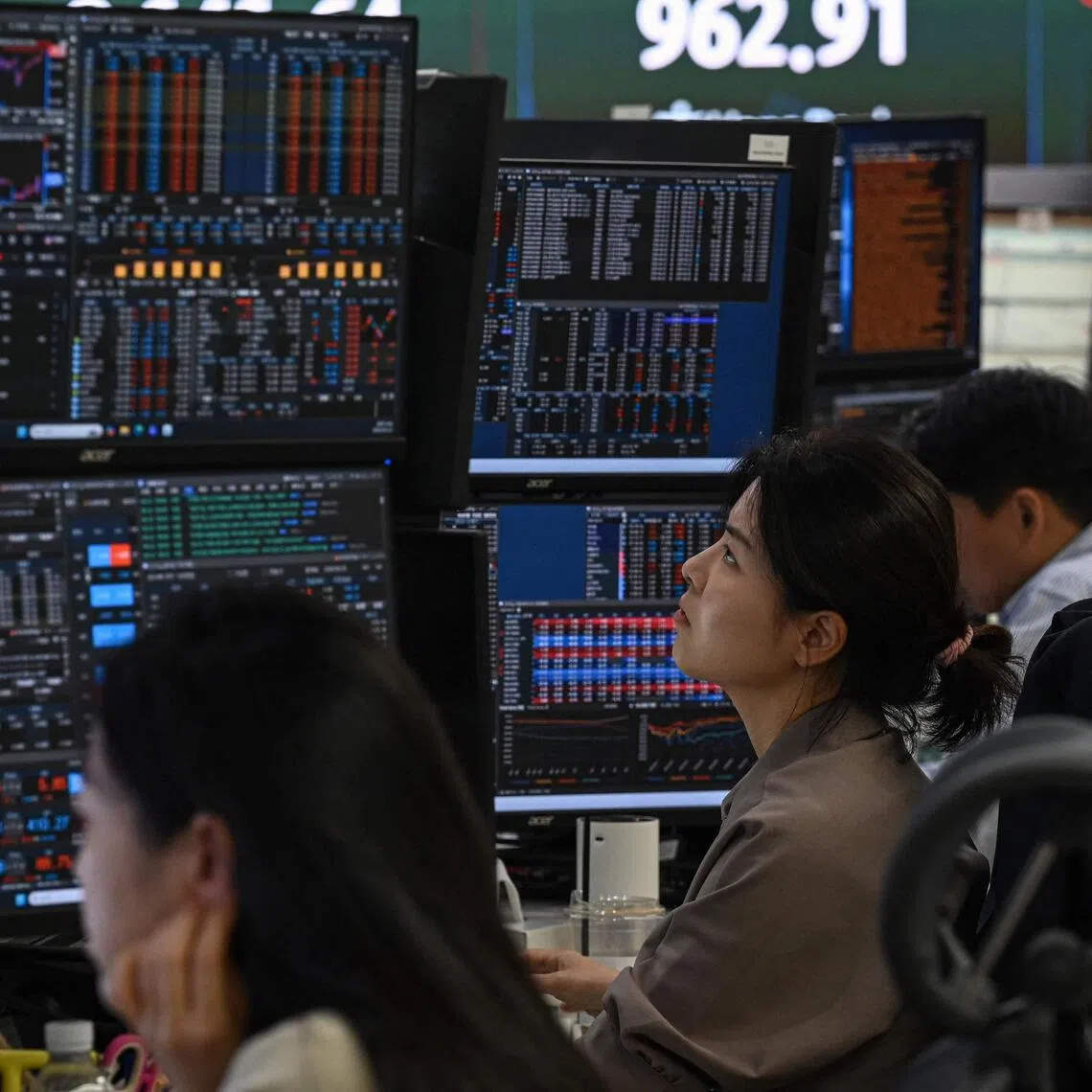 Currency dealers monitor exchange rates in a foreign exchange dealing room at the Hana Bank headquarters in Seoul on June 23.
