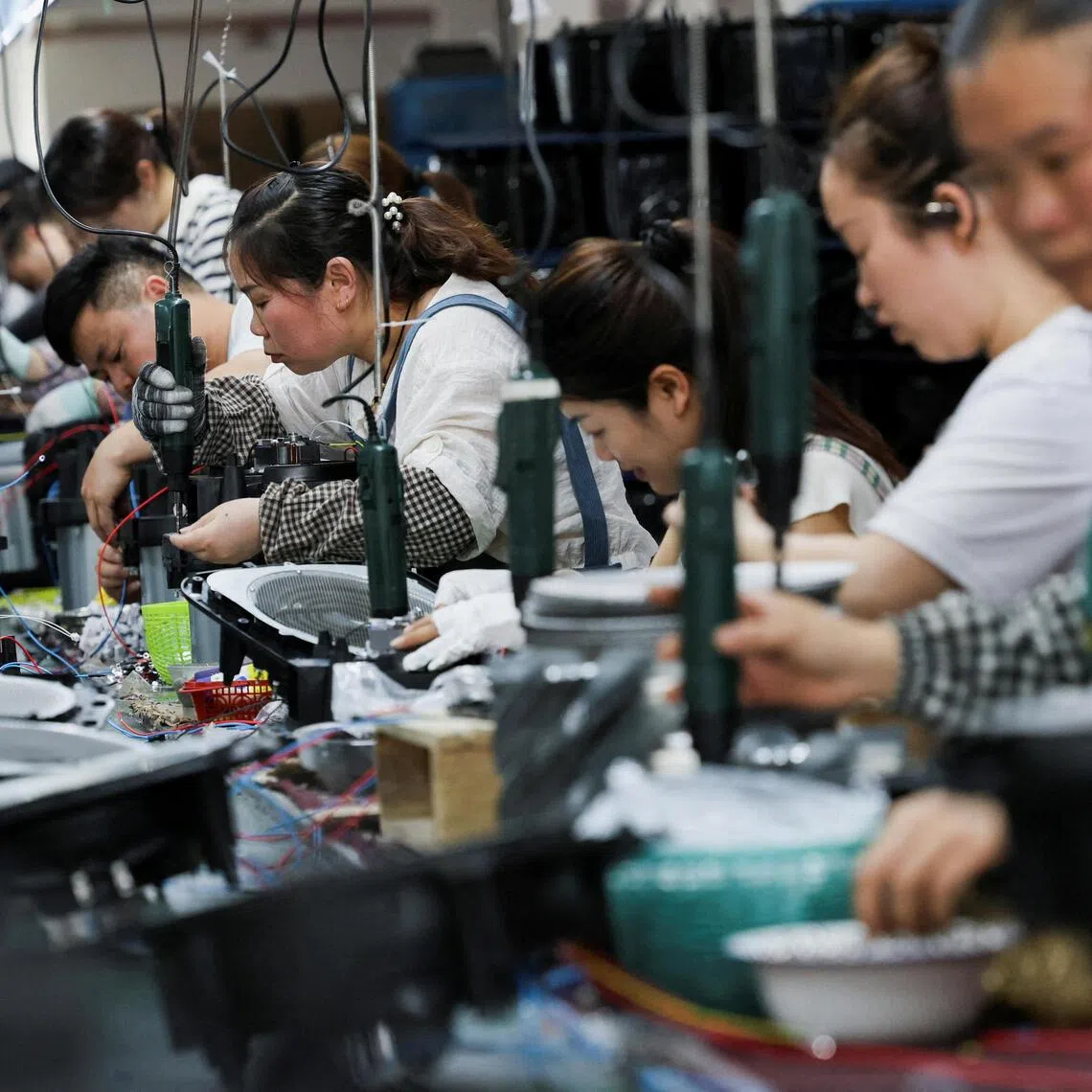 FILE PHOTO: Employees of Gstar Electronic Appliance Co., Ltd work to assemble air fryers in the factory in Ningbo, Zhejiang province, China May 19, 2025. REUTERS/Go Nakamura/File Photo