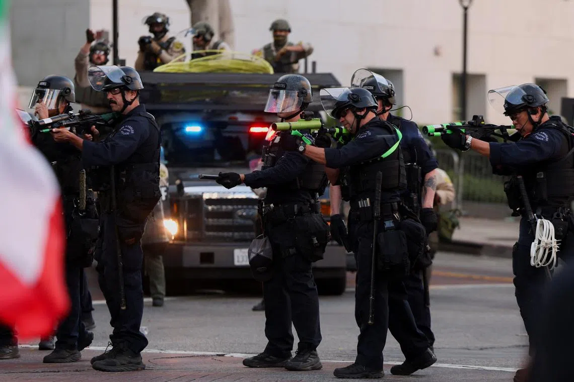 Law enforcement officers shoot non-lethal munitions, as people march as part of the ongoing protests against Immigration and Customs Enforcement (ICE), in Los Angeles, California, U.S. June 11, 2025. REUTERS/Leah Millis/File Photo