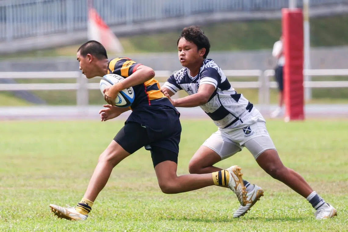 St Andrew’s School captain Tai Jun Yew (right) tackling ACS(I) fly-half Preston Lim during the C Division boys’ rugby final at Jurong West Stadium on Aug 24.