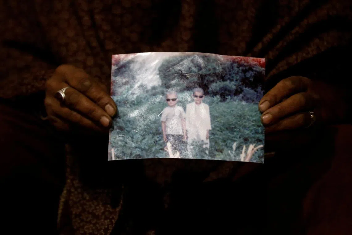 Zahra Ramzan, 40, mother of 11 year-old Ali Mohammad (L), holding his photograph at her home in Chalt village, in the Karakoram mountain range, in the Gilgit-Baltistan region of Pakistan, Oct 10, 2023. In Chalt village, a torrent of black water rushed down the valley last year. Ali Mohammad was swept away. "I'm in very deep grief. I could not see my son again, even a body," she said. 