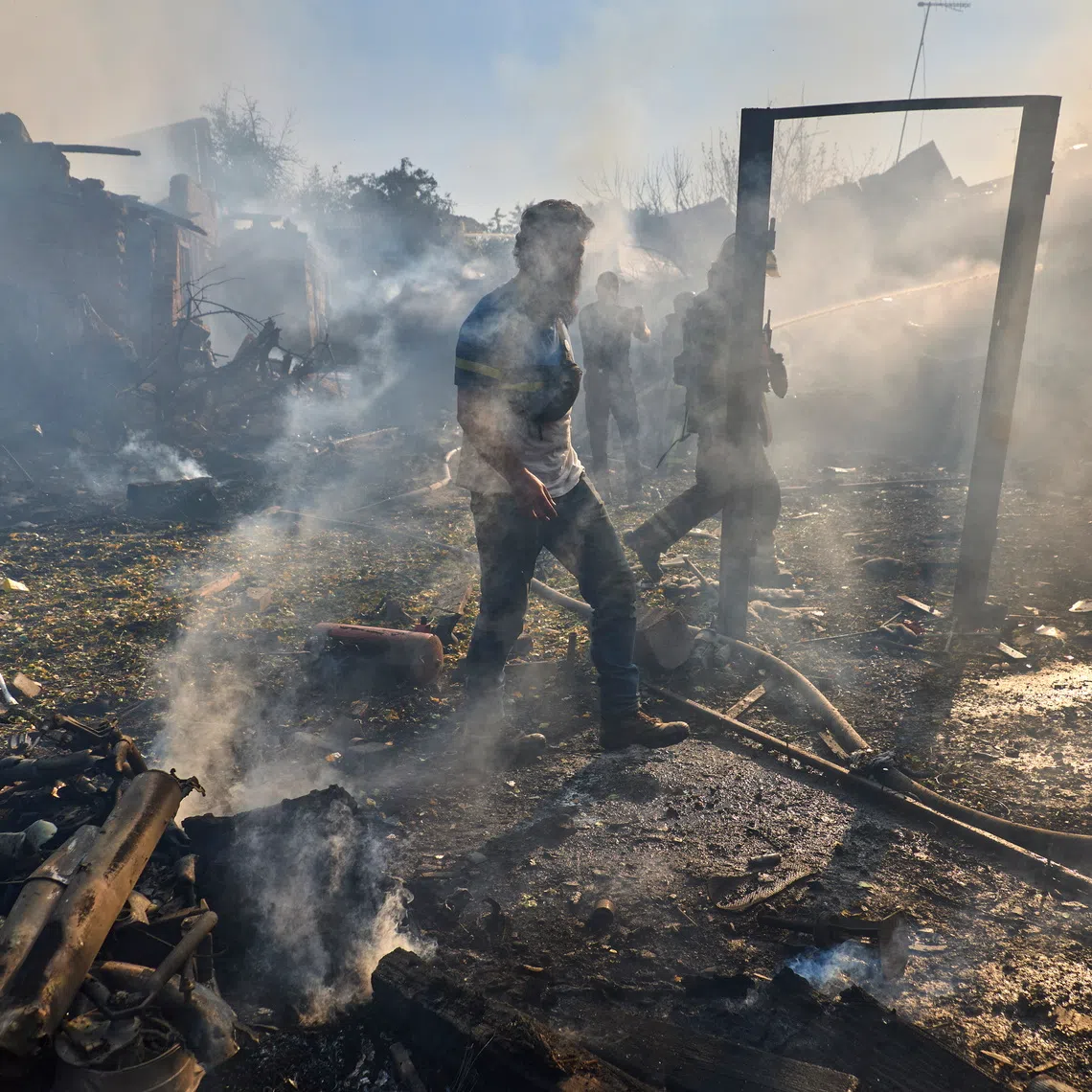 Ukrainian rescuers work at the site of a Russian air strike on a residential area in Kharkiv, north-eastern Ukraine, on Oct 11.