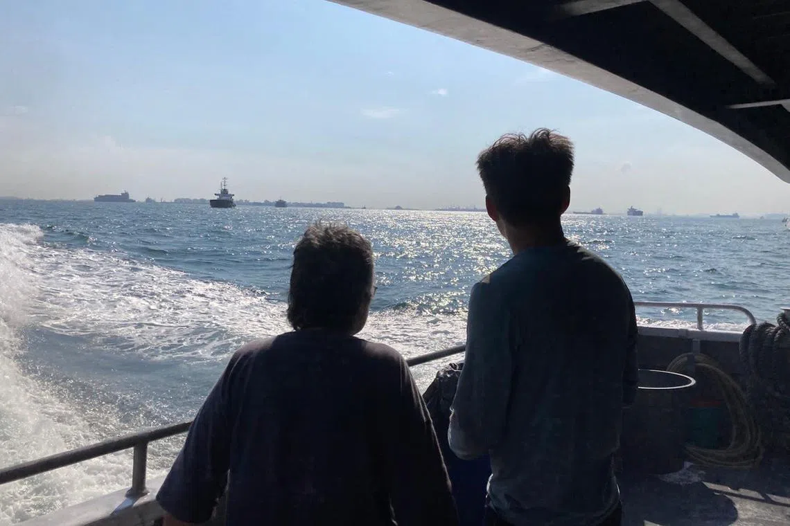 Backviews of Singapore-born artist Simryn Gill and Singaporean artist Charles Lim as they travel down the Malacca Strait, which inspired the exhibition The Sea Is A Field. 