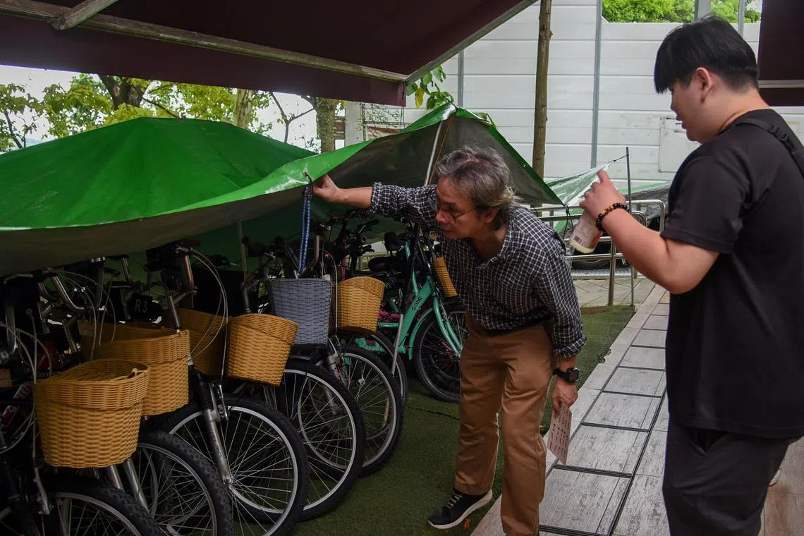 ST Journalist John Lui showing a customer bicycles that are available to rent while working in a bicycle rental shop for a day at Jomando Adventure & Recreations on May 1, 2024. 

ST PHOTO: HENG YI-HSIN
