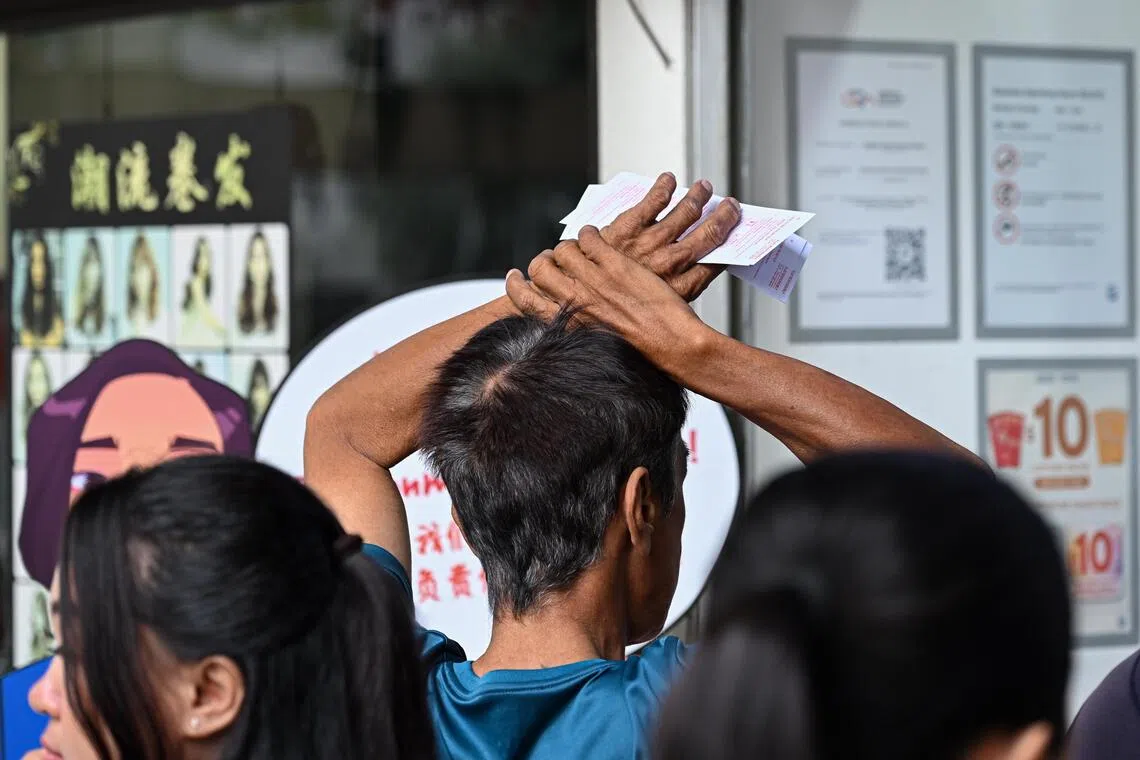 Foreign workers at a Singapore Pools outlet at City Plaza on July 12.