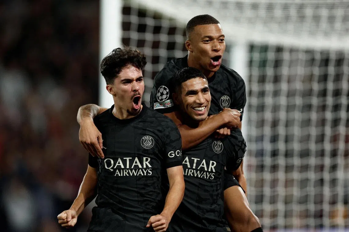 Paris St Germain's Achraf Hakimi celebrates scoring their second goal with Kylian Mbappe and Vitinha.