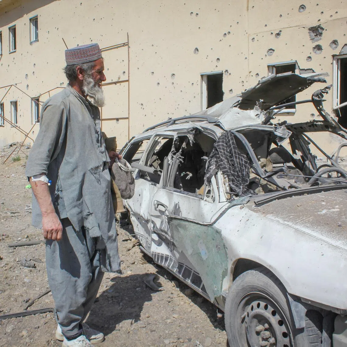An Afghan man stands next to a damaged car following airstrikes, amid the conflict between Afghanistan and Pakistan, in Kandahar, Afghanistan, February 28, 2026. REUTERS/Stringer
