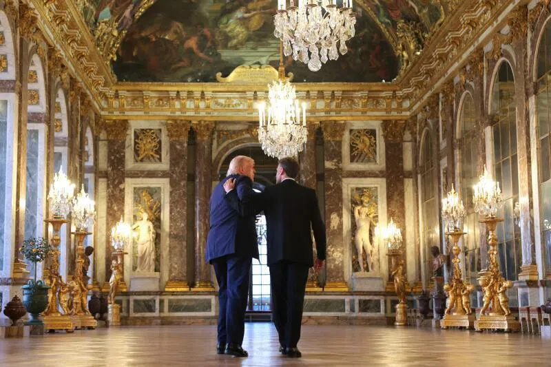 French President Emmanuel Macron (right) giving US President Donald Trump a tour of the Palace of Versailles before the dinner where Trump signed a hard copy of the US-Iran agreement.