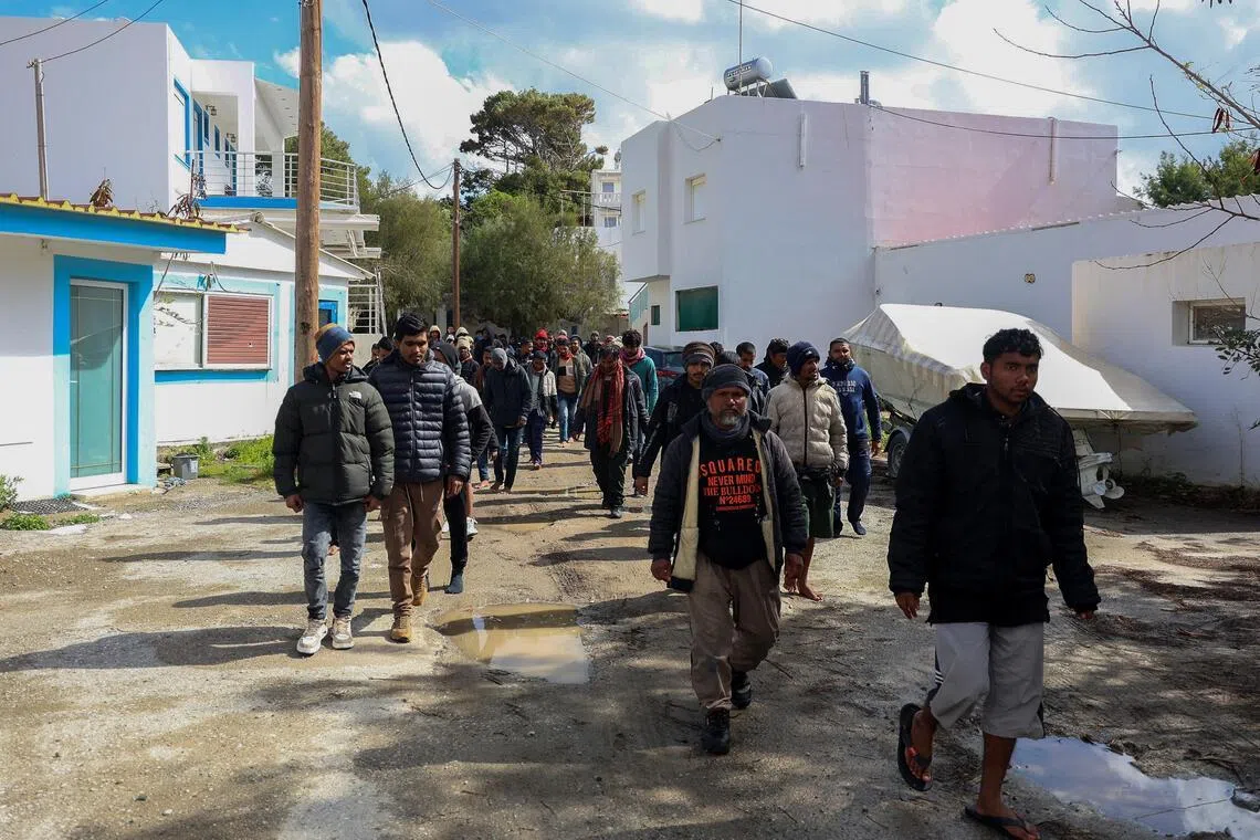 Migrants walk through the village of Kaloi Limenes, on the island of Crete, Greece, February 21, 2026. REUTERS/Stefanos Rapanis