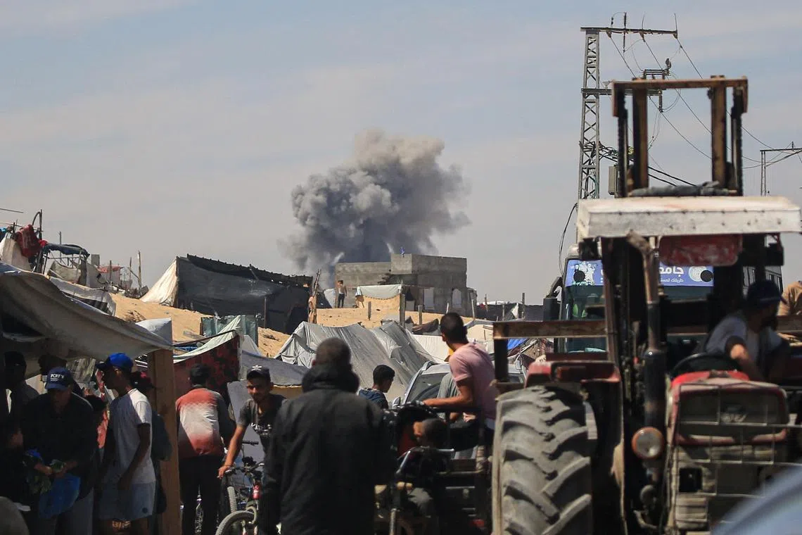 Displaced Palestinians watching in Rafah, in the southern Gaza Strip, as smoke billows from Israeli bombardment, on May 31.