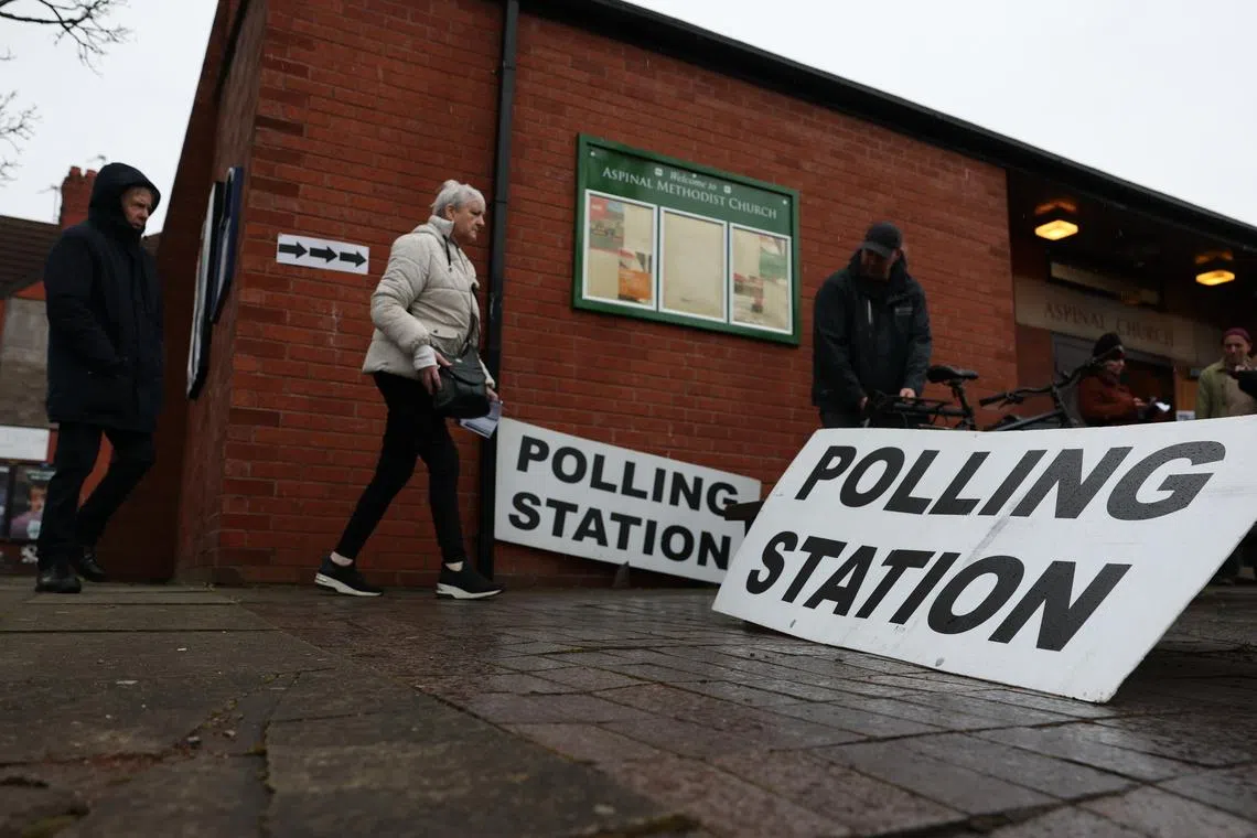 Voters arriving at a polling station in Manchester, Britain, on Feb 26.