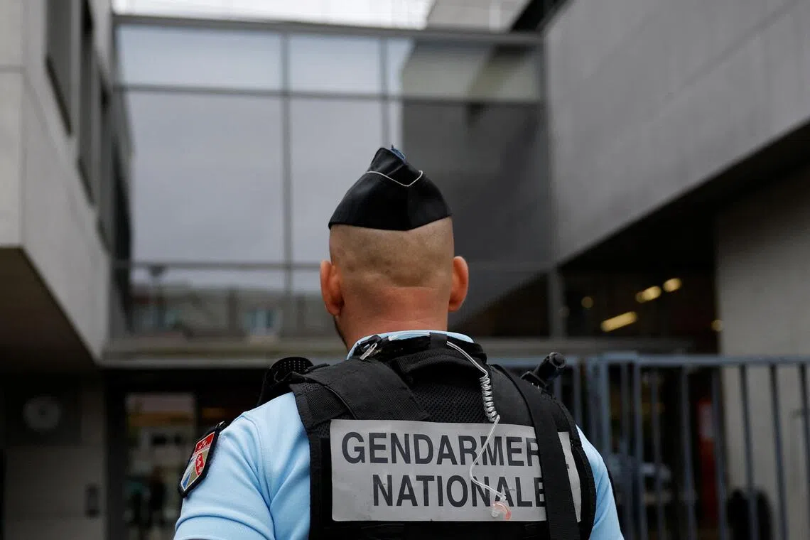 A French gendarme standing in front of a secondary school in France where a teacher was stabbed in class by a 14-year-old student on Sept 24.